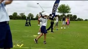 junior golfers at the driving range